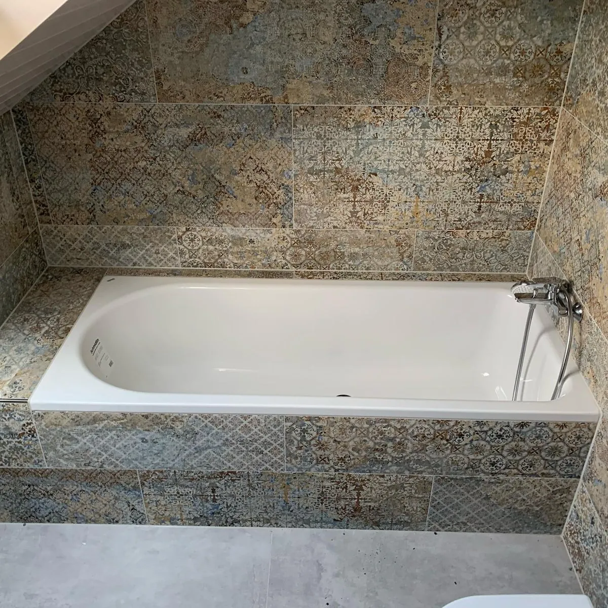 Neue Badewanne mit gemusterten Fliesen