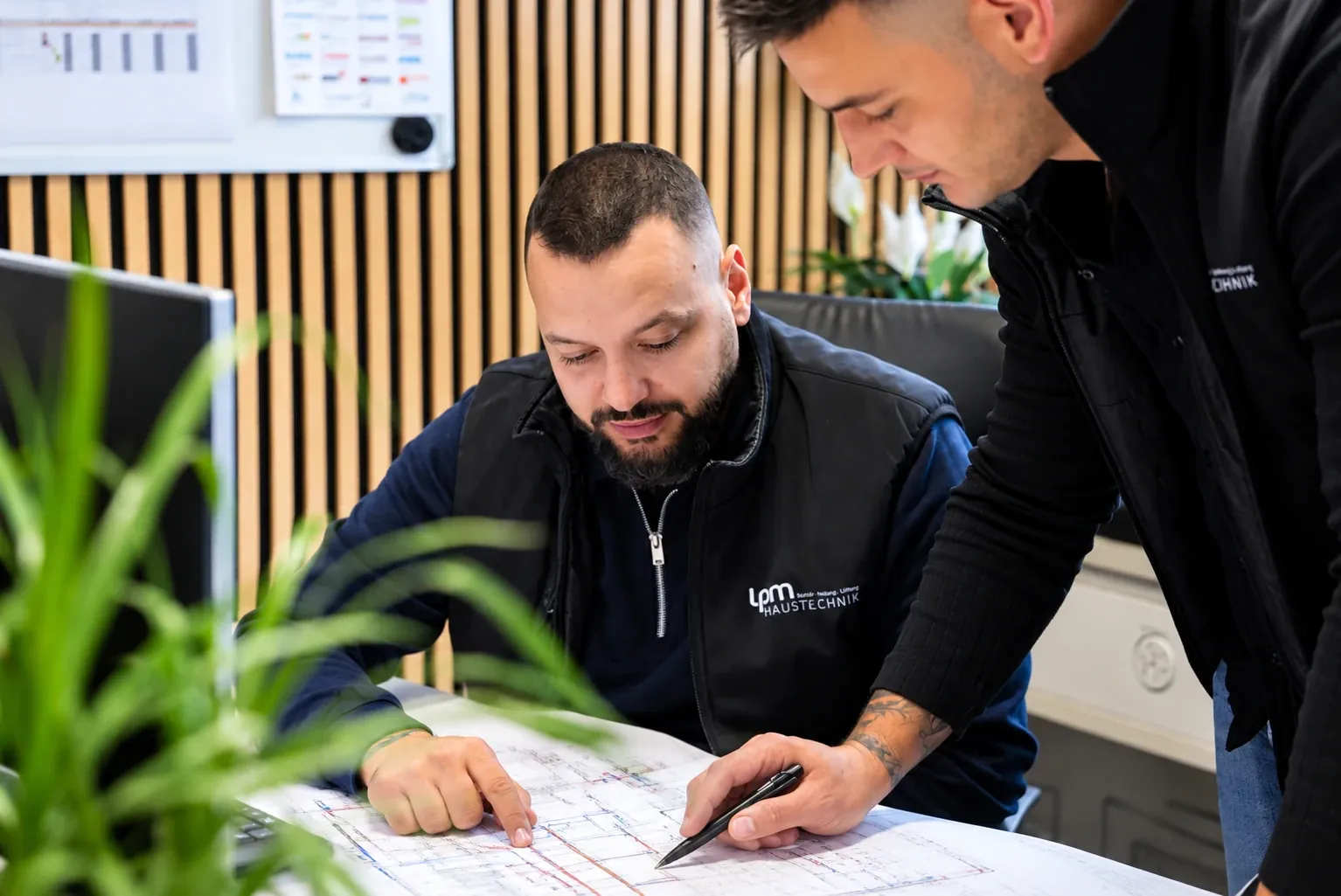 Zwei Mitarbeiter von LPM Haustechnik besprechen einen Plan